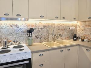 a kitchen with a stove and a sink at La Casa Buranella in Lefkada