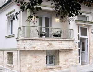 two chairs sitting on a balcony on a building at Memories House in Edessa