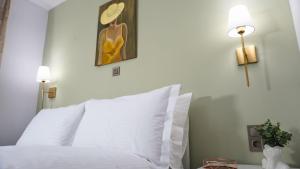 a bedroom with a white bed and a painting on the wall at Memories House in Edessa