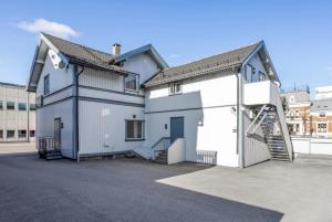 a large white house with a garage and a staircase at Sentral 1BR i Porsgrunn - P Apartments in Porsgrunn