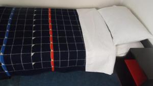 ein Bett mit einer Decke und Kissen darauf in der Unterkunft Motel Hrasno in Čapljina