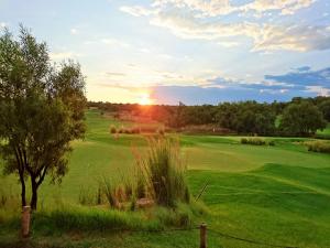 a view of a golf course with the sun setting at Elements Private Golf Reserve in Bela-Bela +49 photos