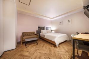 a hotel room with a bed and a chair at No25 Hotel Ansan in Ansan