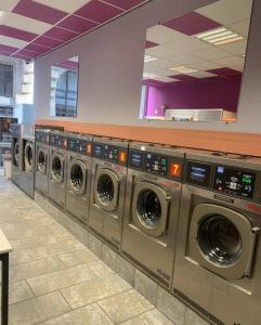 een rij wasmachines in een wasruimte bij Grand Duplex avec 2 chambres in Charleroi