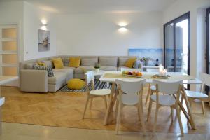 a living room with a couch and a table and chairs at Oasis Premium Twin in Primošten