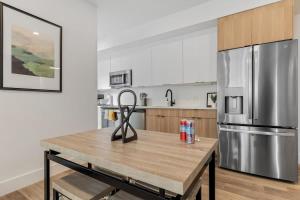 a kitchen with a wooden table and a stainless steel refrigerator at NoMa Convenience 2-BR Near Metro Union Market in Washington, D.C.