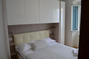 a bedroom with a bed and a window and a mirror at Hotel San Pietro Chiavari in Chiavari