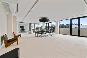 un soggiorno aperto con tavolo e sedie di Guest INN Home - Elements Suites a Tulum