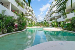 una piscina al centro di un edificio di Guest INN Home - Elements Suites a Tulum