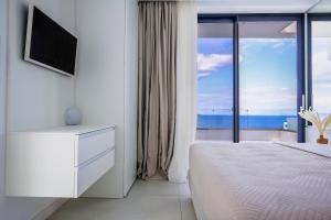 Un dormitorio blanco con vista al mar. en Villa OMORFI, en Kókkinon Khoríon 47 fotos más