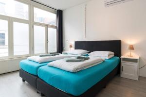 two large beds in a room with large windows at RedLight District Private Smokers Friendly Studio in Amsterdam