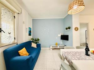 salon z niebieską kanapą i stołem w obiekcie San Lorenzo Holiday w mieście Reitani
