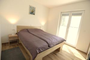 a bedroom with a bed and a large window at Apartmaji Valentina in Premantura