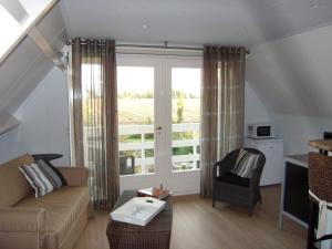 a living room with a couch and a window at In de Wolken in Giessenburg