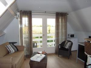 uma sala de estar com um sofá e uma janela em In de Wolken em Giessenburg
