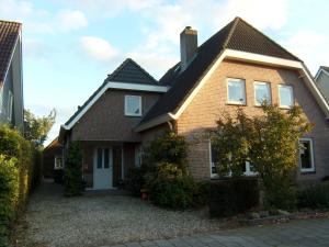 a brown brick house with a roof at In de Wolken in Giessenburg