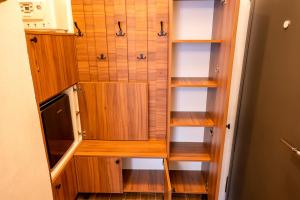 a closet with wooden shelves and a microwave at Stradela in Sighişoara