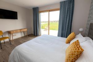 a hotel room with a bed and a sliding glass door at Chez Watersy in Belle-et-Houllefort