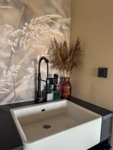 a white sink in a counter with a vase at De Hooiberg in Made +10 photos