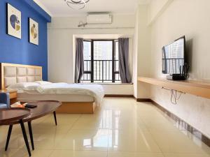 a bedroom with a bed and a table in a room at Guangzhou Phantom Oasis Apartments - Canton Fair Exhibition Area in Guangzhou