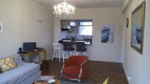 un salon avec un canapé et une cuisine dans l'établissement Ocean Elephant Beach Apartment, à Strand