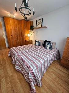 una camera da letto con un letto grande con una coperta a righe di Ezcaray Pet Friendly, piscina y parking a Zorraquín