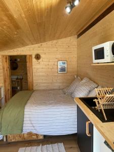 a bed in a small room in a log cabin at cabane in Saint-Vincent-de-Paul