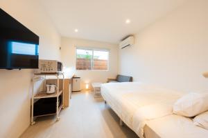 una camera da letto con un letto e una TV a schermo piatto di Hotel Meguri a Usa