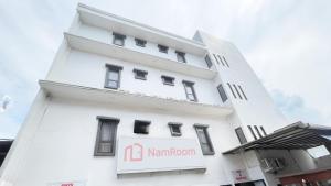 a white building with a sign on it at NamRoom at Kalimalang in Cibening