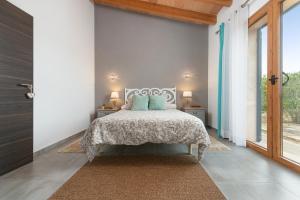 塞萨利内斯Can Xesquet Comuna - Ses Salines的一间卧室，里面有一张床和一扇大窗户。