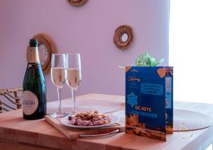 a bottle of wine and two glasses on a table at L'Ecrin d'Albi - Love Room - 1 chambre in Albi
