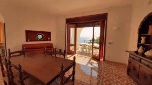 a living room with a table and a view of the ocean at Villa Ubertina - Tricase Porto in Marina Porto
