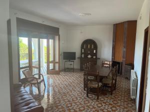 a living room with a table and chairs and a television at Villa Ubertina - Tricase Porto in Marina Porto