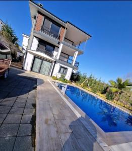 a house with a swimming pool in front of it at Villa Şile Ahmetli Schlicht und elegant in Ahmetli
