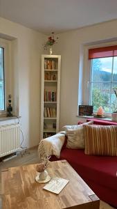 een woonkamer met een rode bank en een tafel bij Ferienwohnung Am Wald in Großschönau