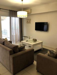a living room with two couches and a flat screen tv at KadroVilla II in Nafplio