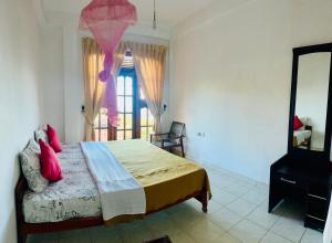 a bedroom with a bed with red pillows and a mirror at ABC Guest Inn & Restaurant in Haputale
