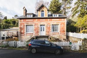 a car parked in front of a brick house at Villa Marguerite in Veulettes-sur-Mer