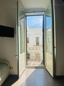 Drzwi otwarte na balkon z widokiem na budynek w obiekcie Nova Domus w mieście Castellaneta