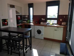 a kitchen with a table and a washing machine at APPARTEMENT 100m DE LA PLAGE ST PIERRE in Saint-Pierre