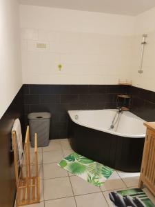 a bath tub in a bathroom with a black and white at APPARTEMENT 100m DE LA PLAGE ST PIERRE in Saint-Pierre