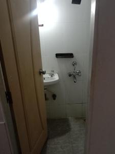 ムンバイにあるSrujan Sarai Service Apartmentのバスルーム(シンク、壁の照明付)