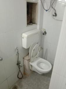 ムンバイにあるSrujan Sarai Service Apartmentの蓋が閉まったトイレのある浴室