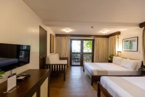 a hotel room with two beds and a flat screen tv at Palm Beach Resort in Biga
