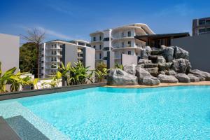 a swimming pool in front of some apartment buildings at Poolside Duplex In Nai harn UTL A102 in Rawai Beach