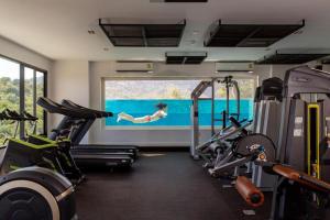 a gym with two treadmills and a person in the water at Poolside Duplex In Nai harn UTL A102 in Rawai Beach