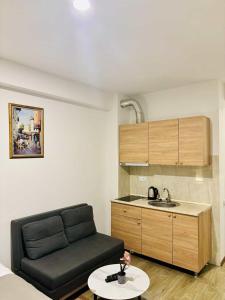 a living room with a black couch and a kitchen at tribu apart hotel in Bakuriani