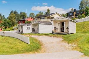 a row of houses on a hill with a fence at Sandli Overnatting in Alvdal
