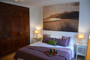1 dormitorio con 1 cama y una pintura en la pared en Villa Jupe, en Tías