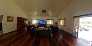 a living room with couches and a flat screen tv at Villa ASIA in Nosy Be